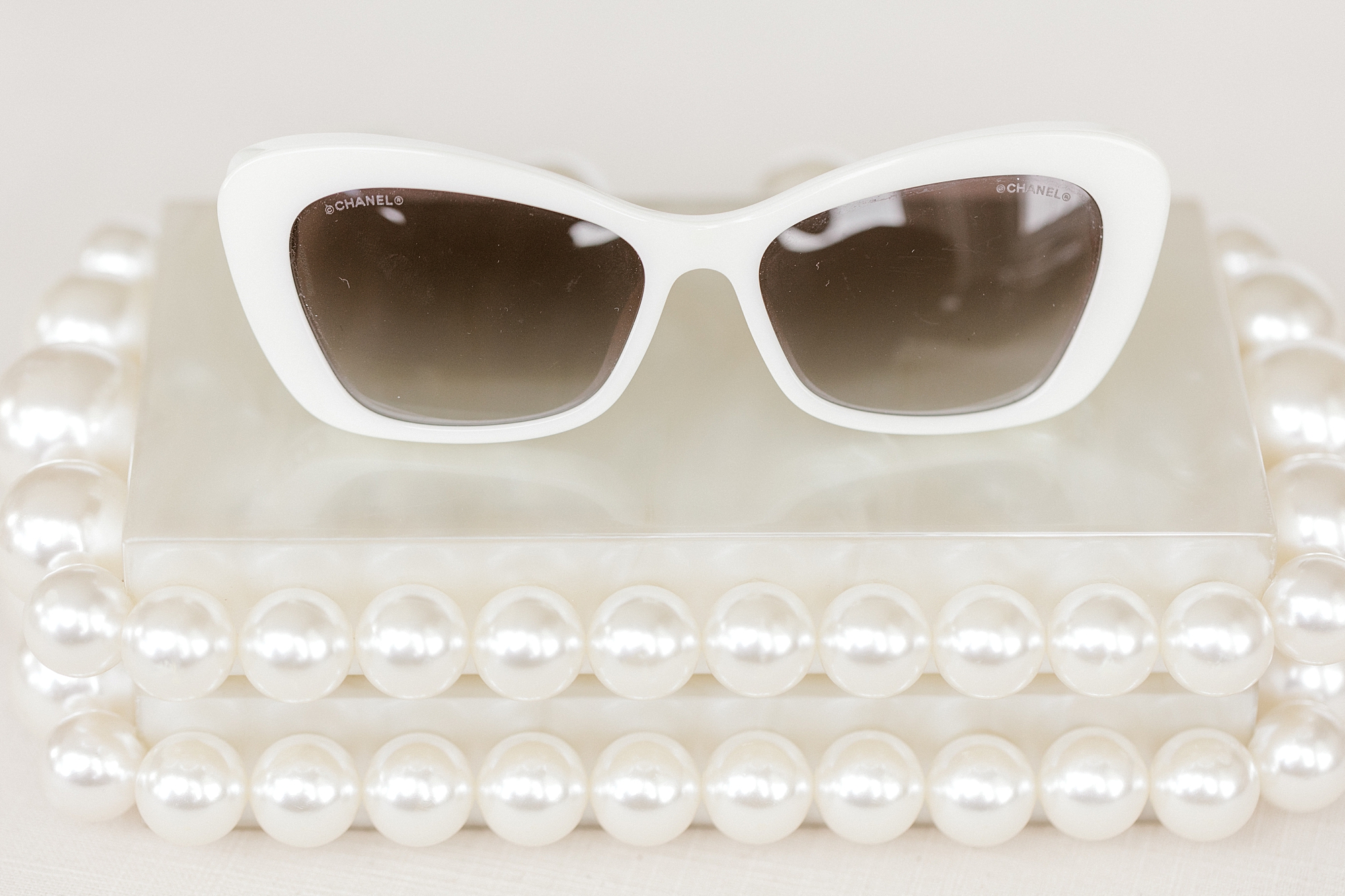 pearls lay around white sunglasses for LBI wedding day
