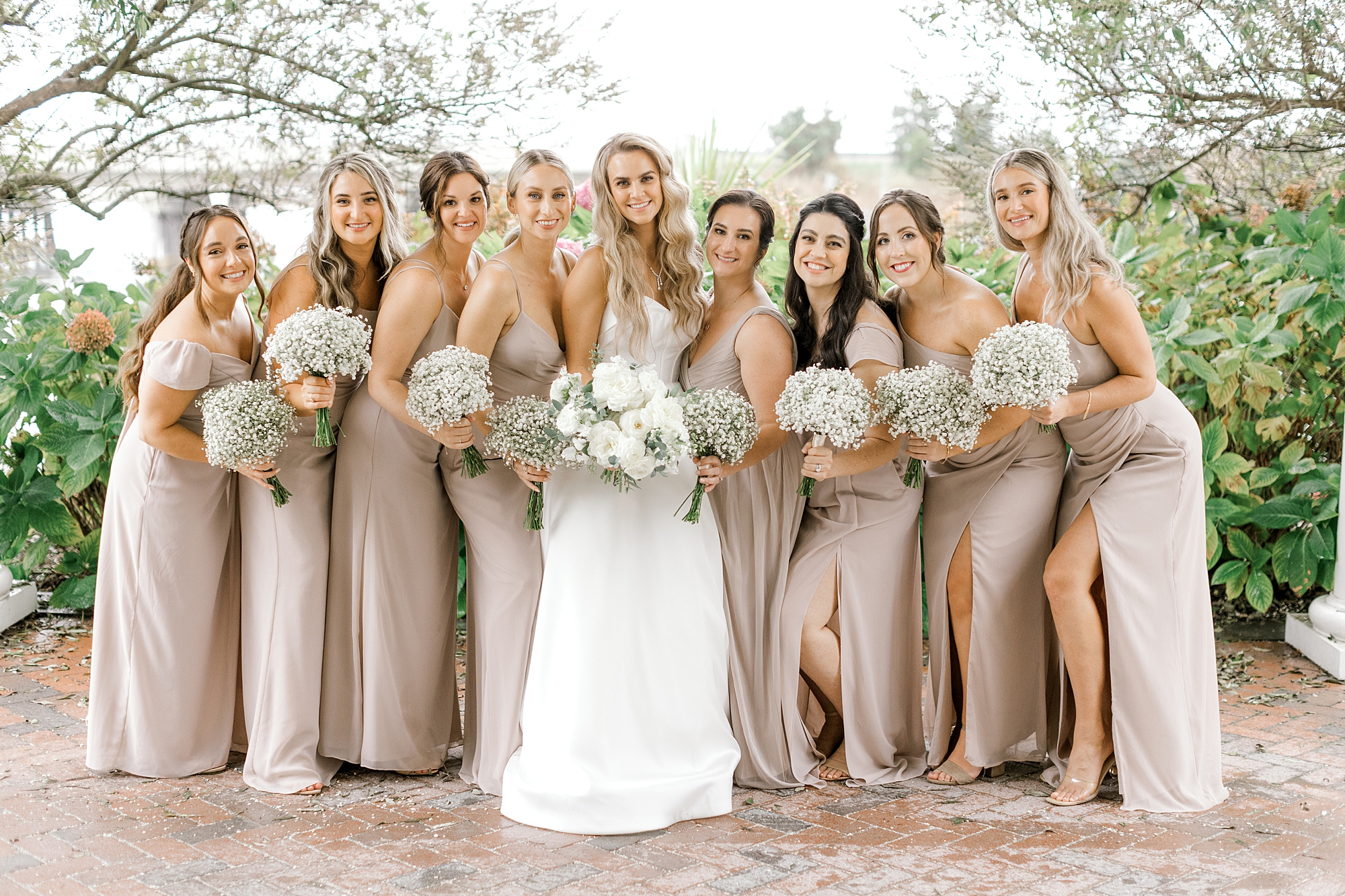 bride and bridesmaids pose holding bouquets of baby's breath outside Bonnet Island Estate