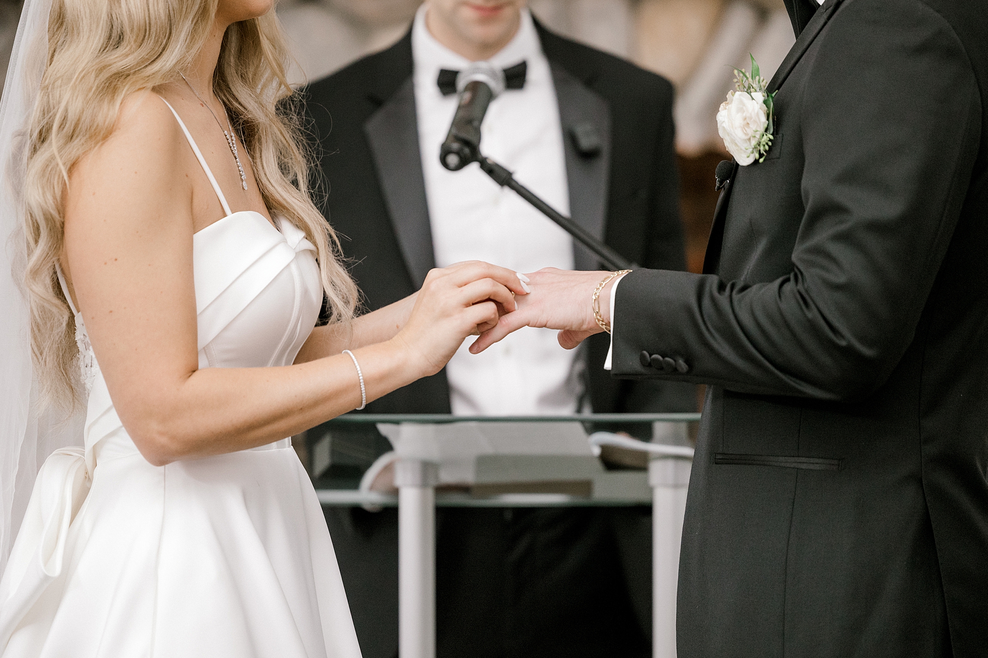 bride places groom's rig on finger during wedding ceremony at Bonnet Island Estate
