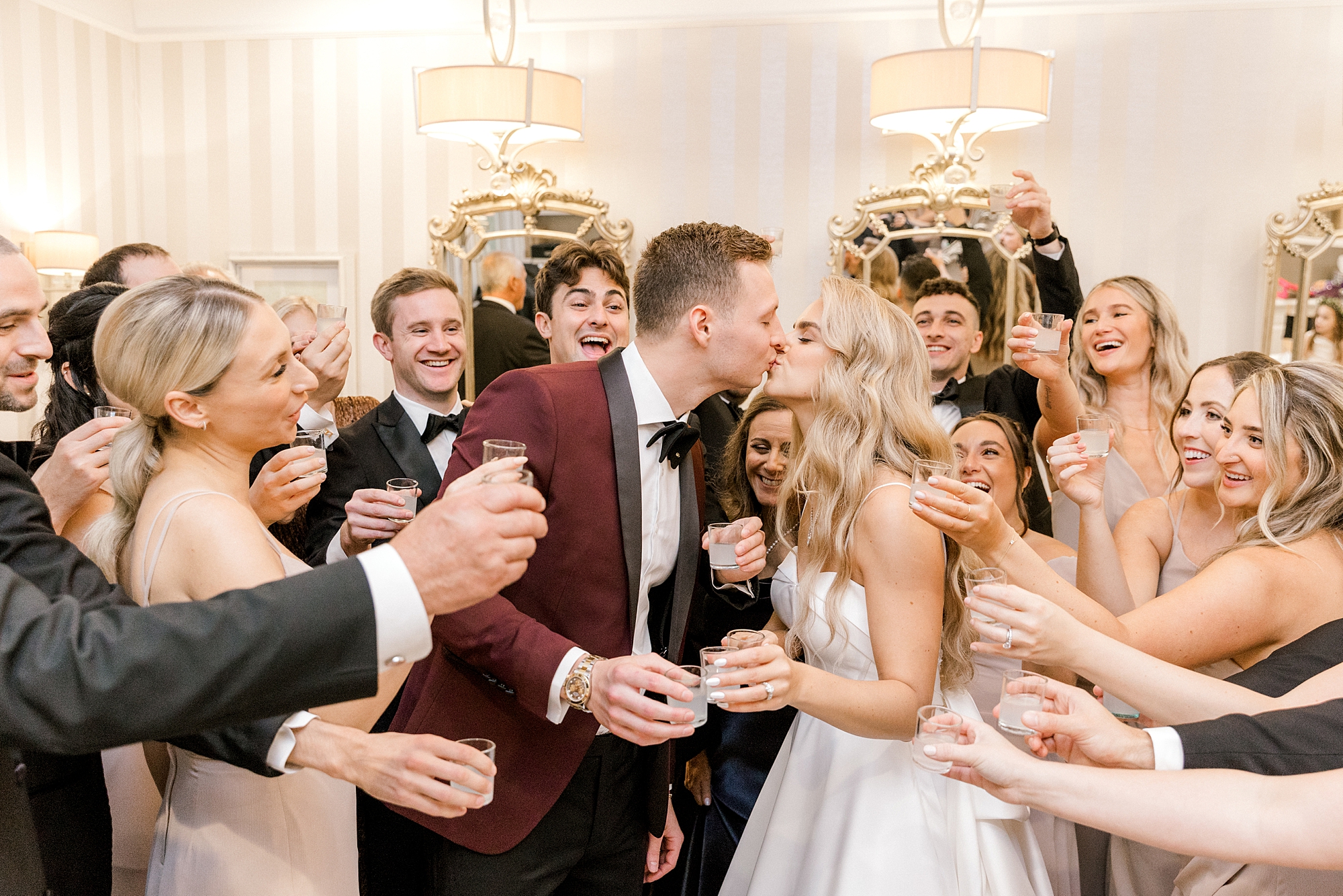 newlyweds kiss after taking shots with wedding party