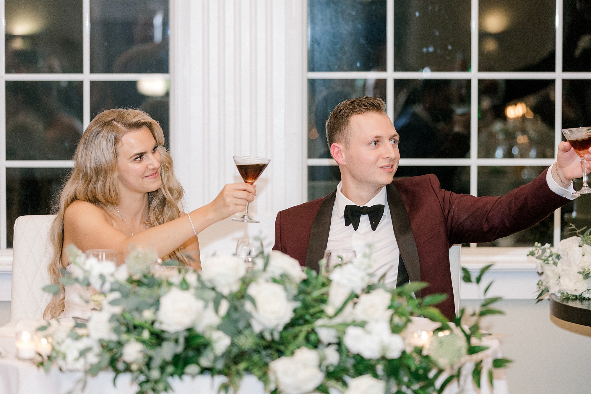 newlyweds lift up custom martinis during toasts at Bonnet Island Estate