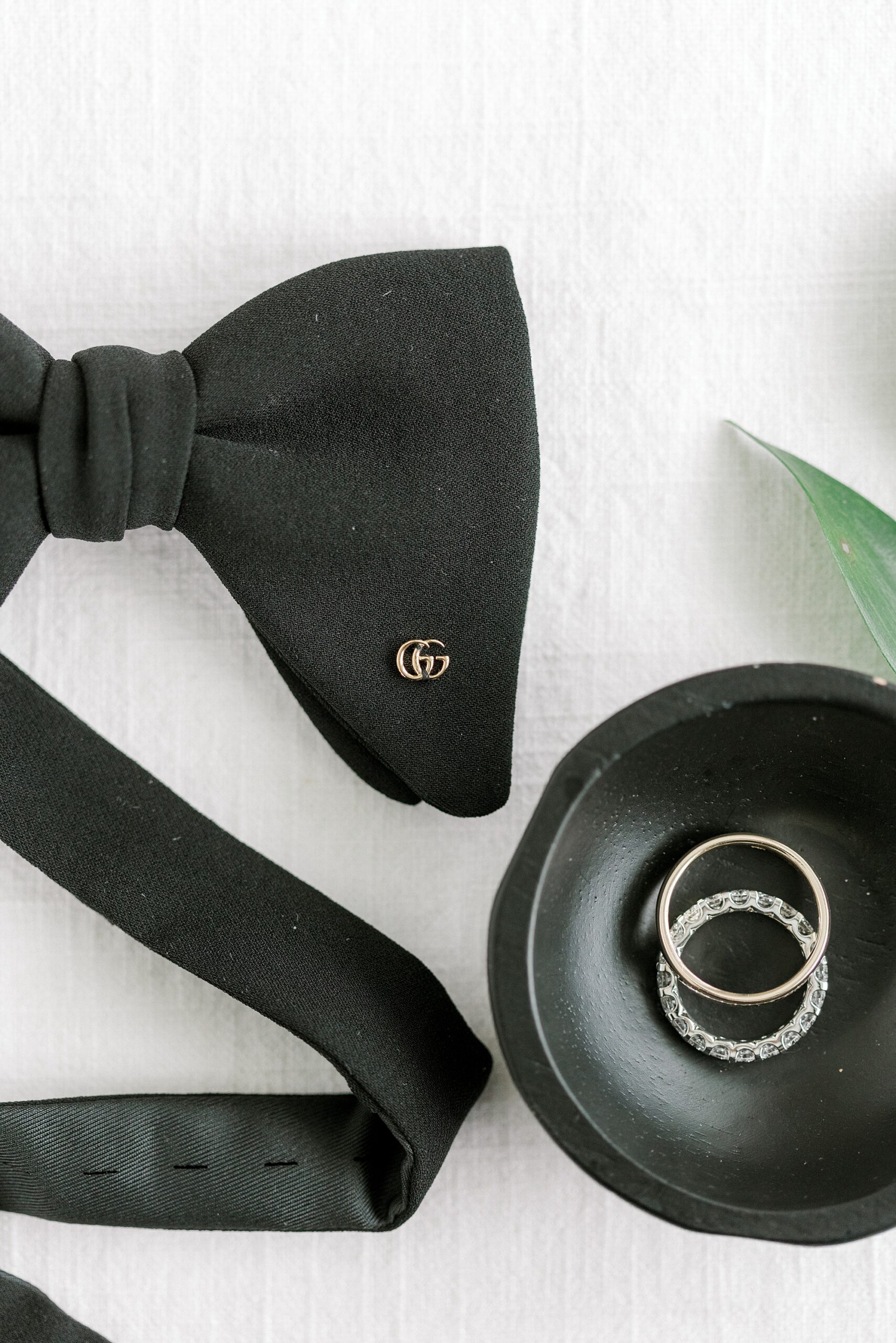 groom's black bow tie and rings in black bowl