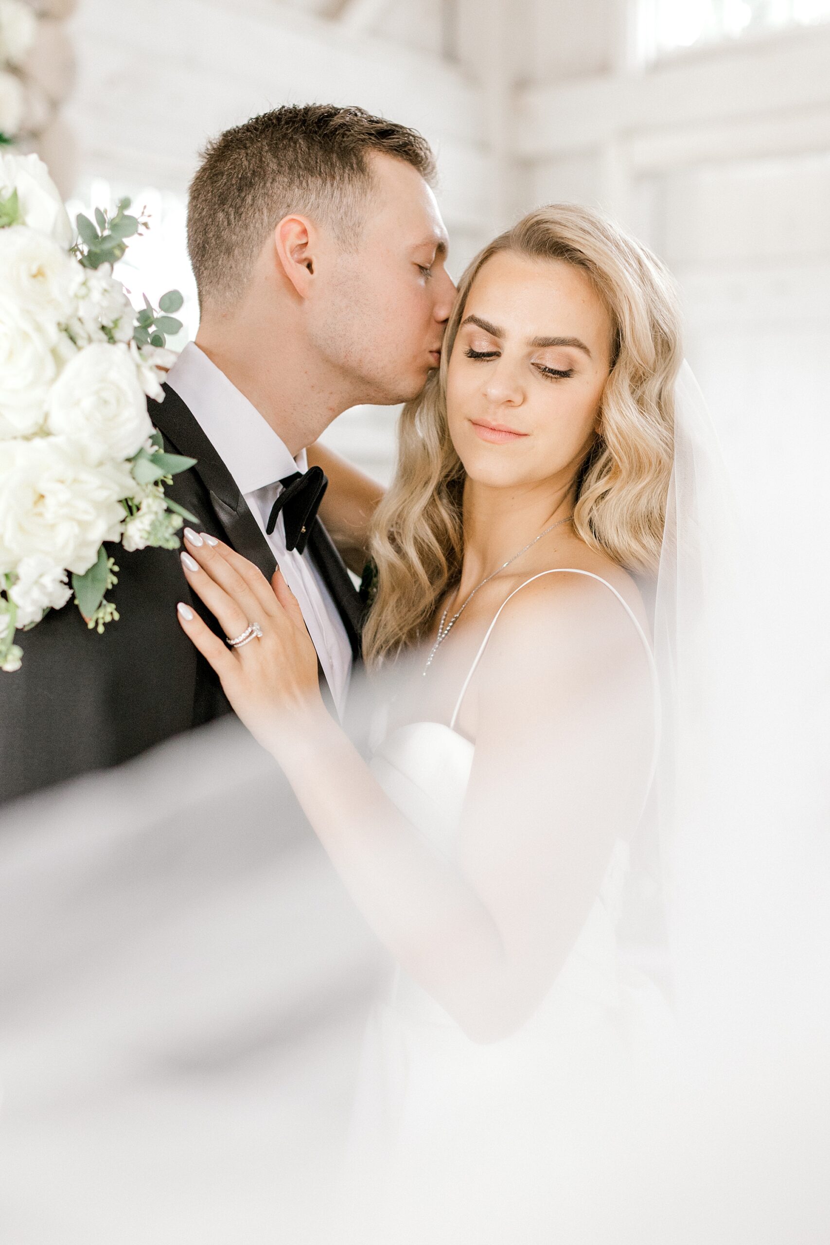 groom leans to kiss bride's cheek during Bonnet Island Estate wedding photos