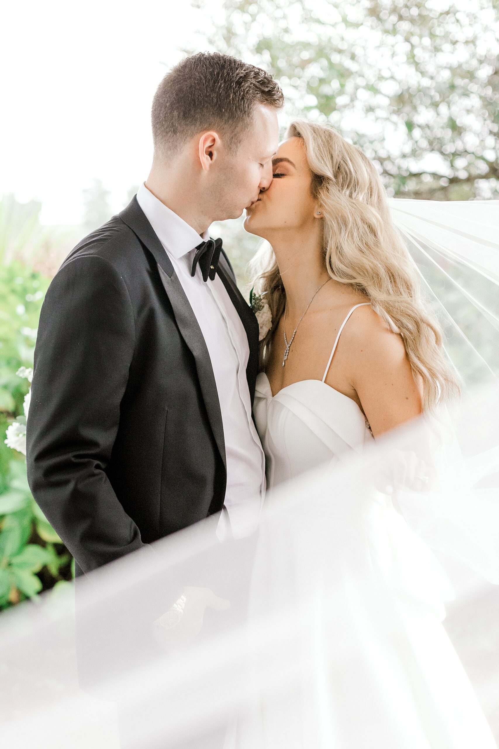 bride and groom kiss with veil around them during LBI wedding portraits