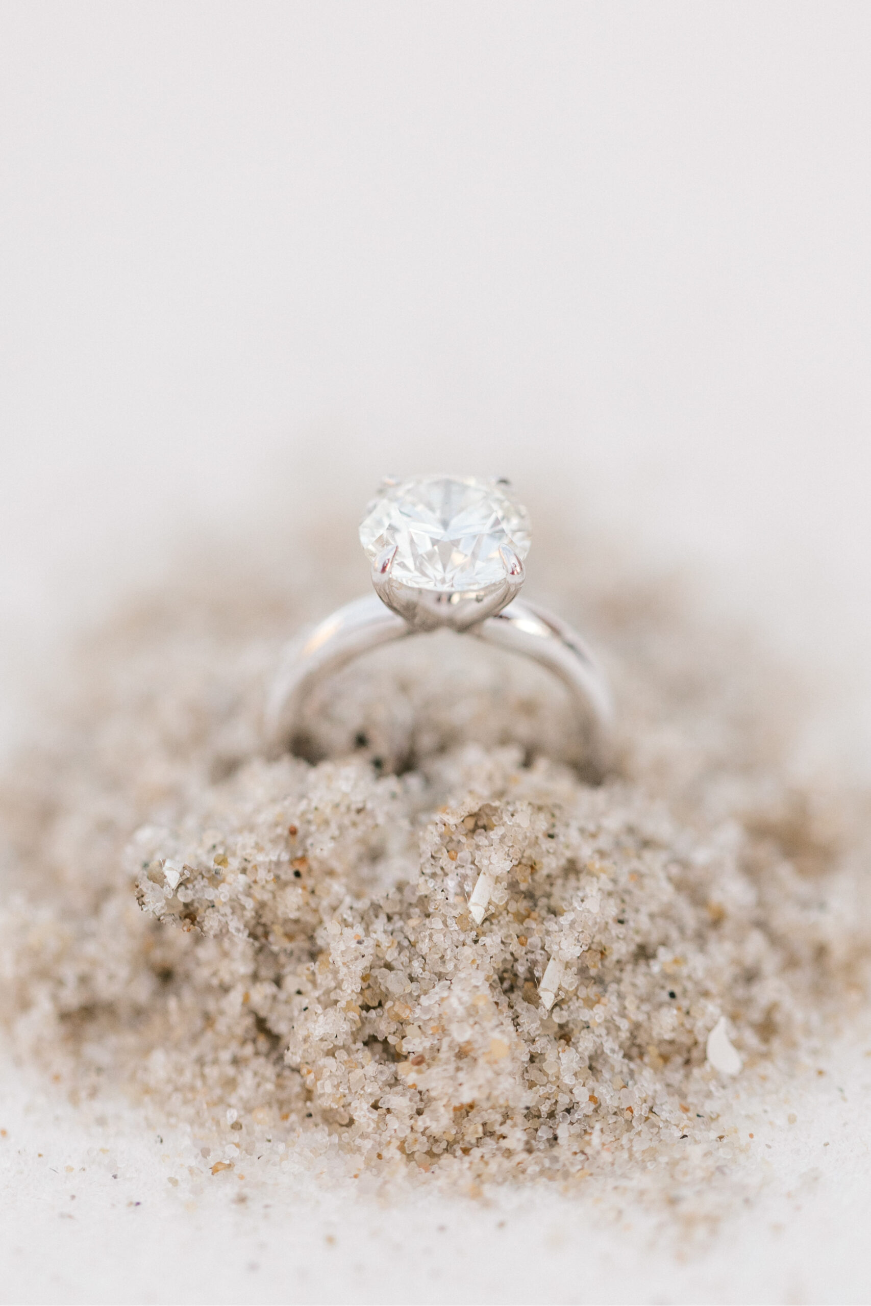 diamond ring rests in sand during Brant Beach engagement session