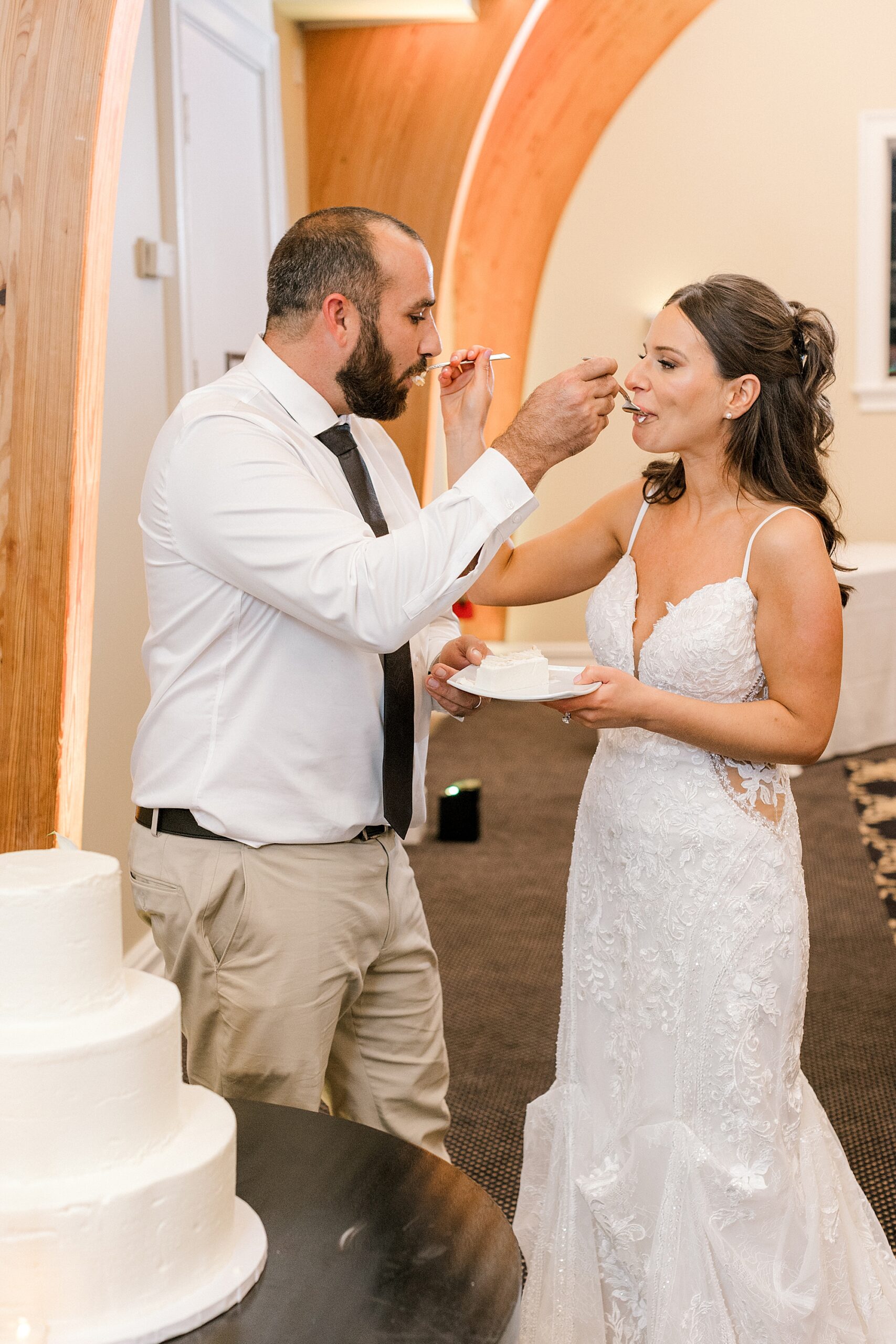 bride and groom feed each other cake during LBI wedding reception