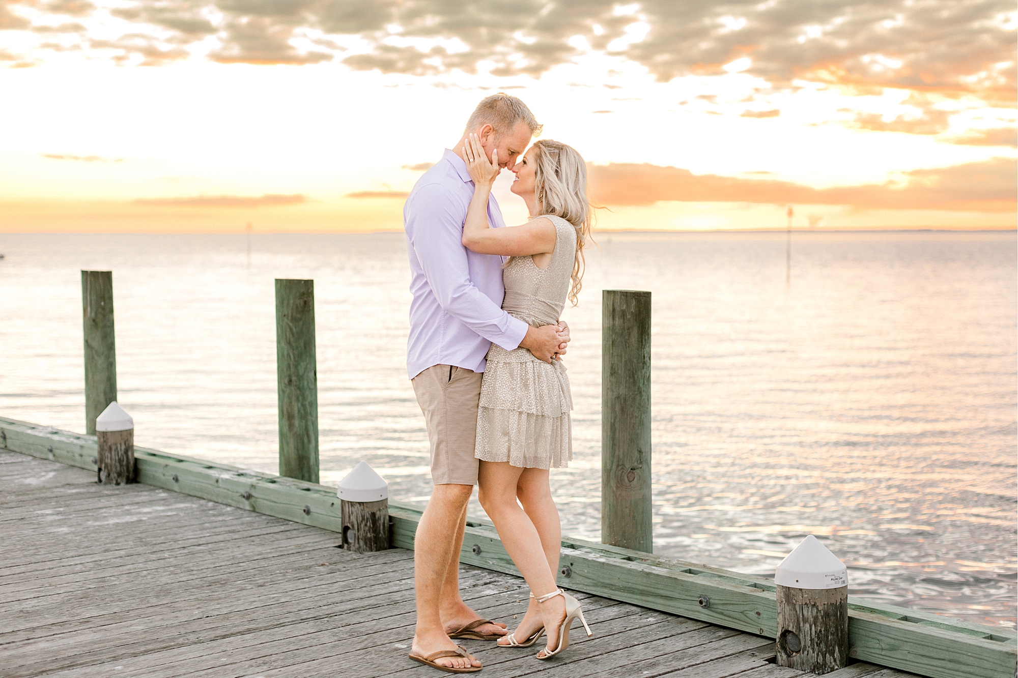 engaged couple kisses on dock at sunset during Long Beach Island engagement session
