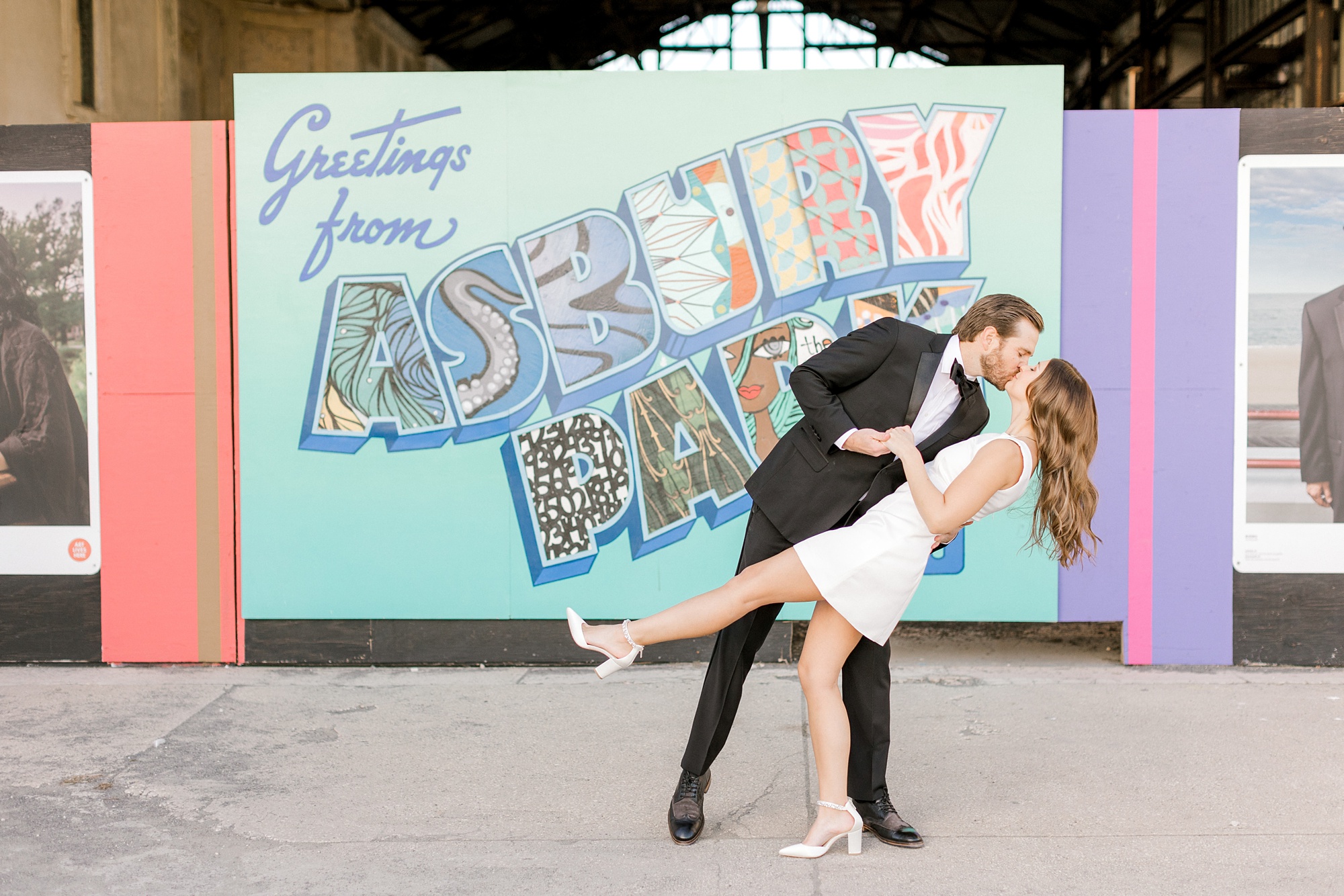 man dips fiancee in front of colorful Asbury Park sign
