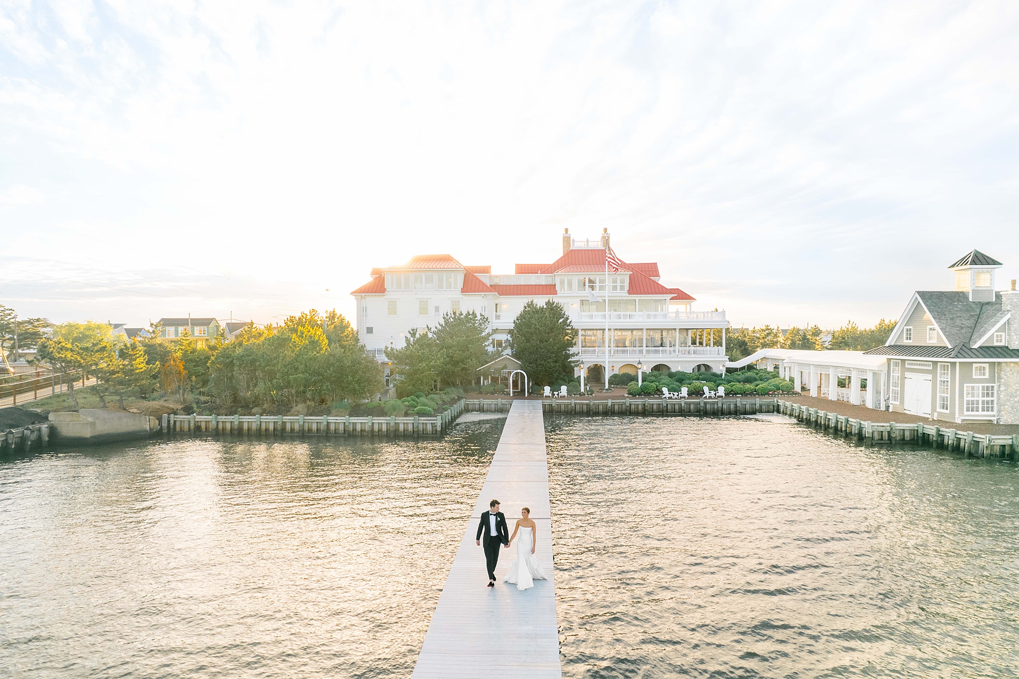 bride and groom walk on dock outside Mallard Island Yacht Club