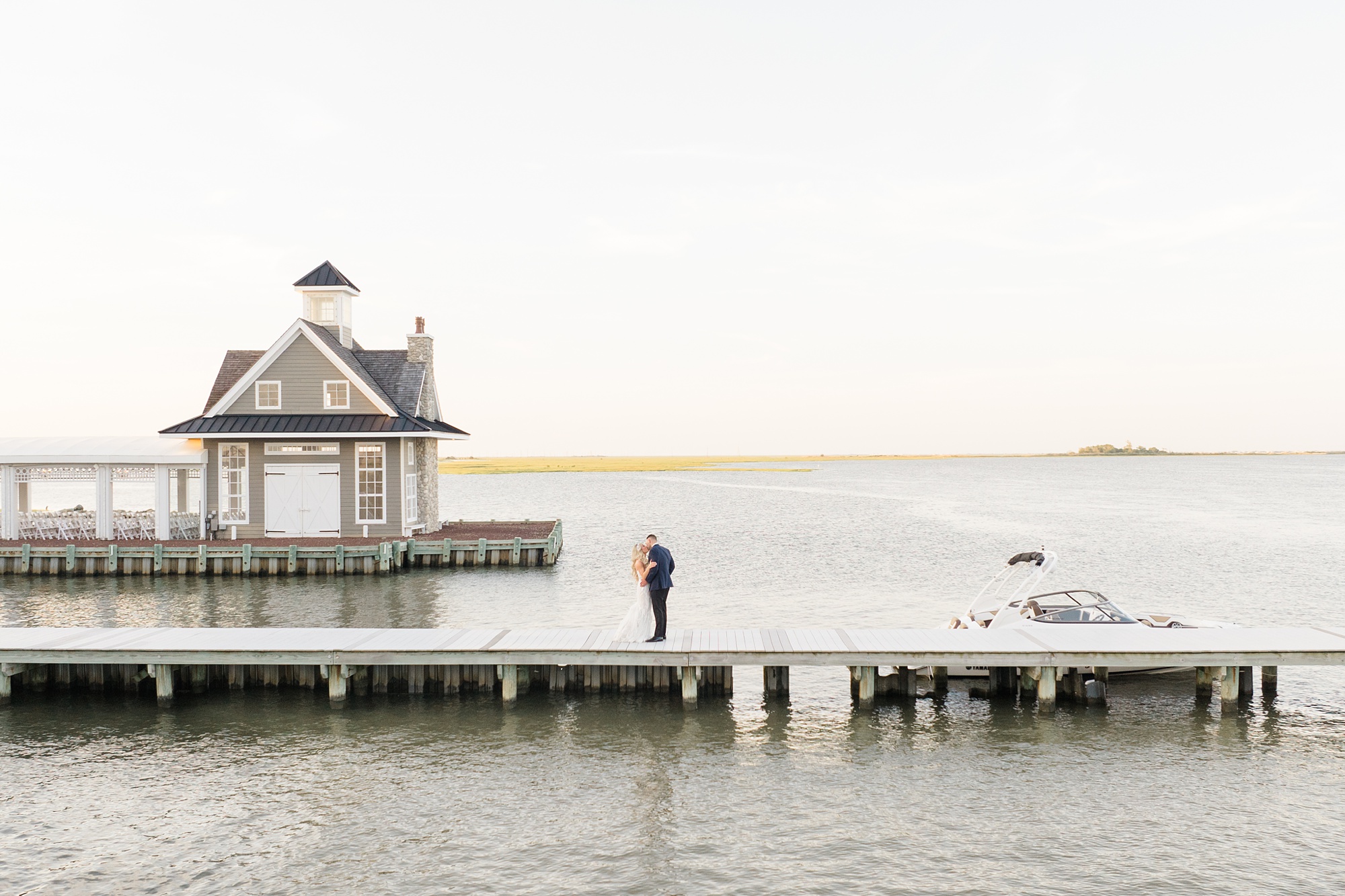 bride and groom kiss on dock at Mallard Island Yacht Club