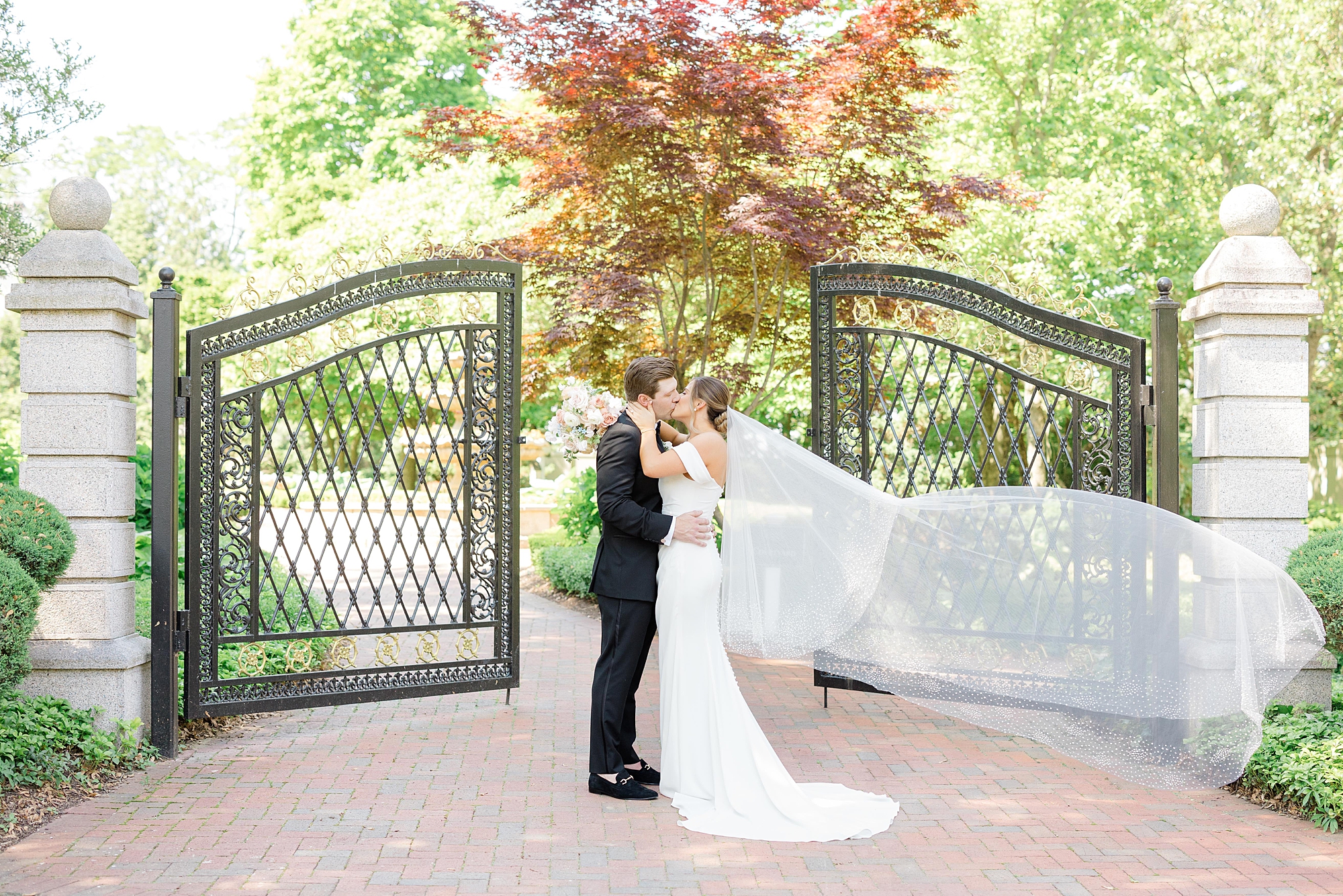 newlyweds kiss by gate at the Ashford Estate