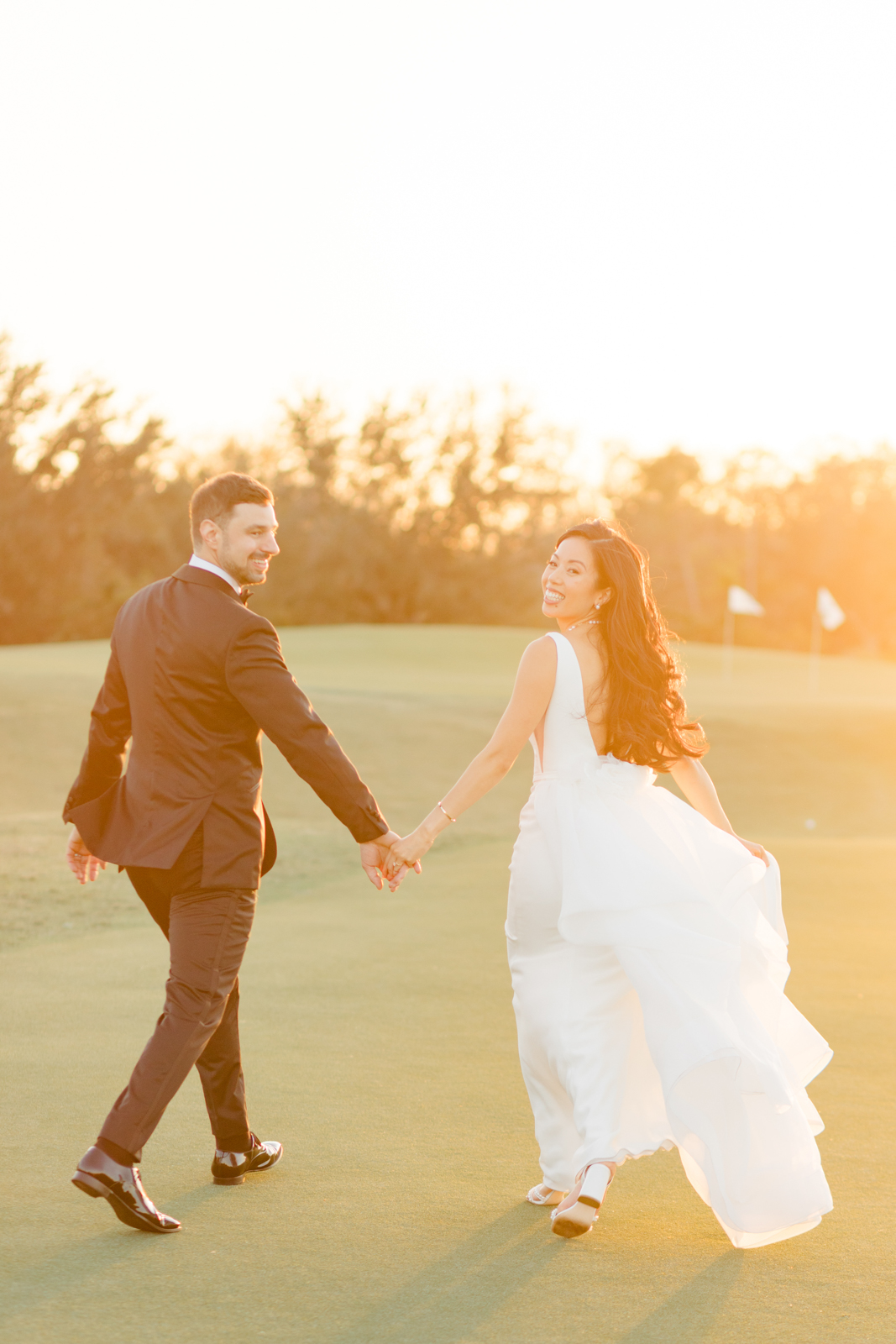 Bride and groom hold hands during golden hour Lakewood Ranch Golf Country Club