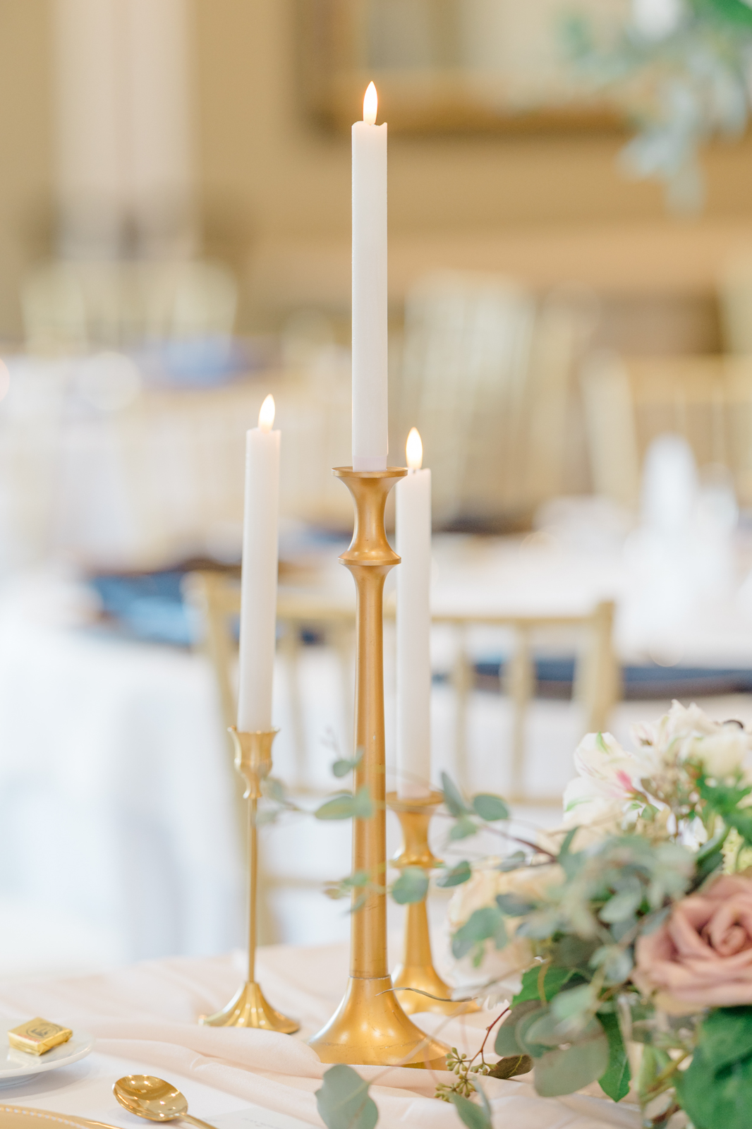 Gold and white taper candles on reception tables