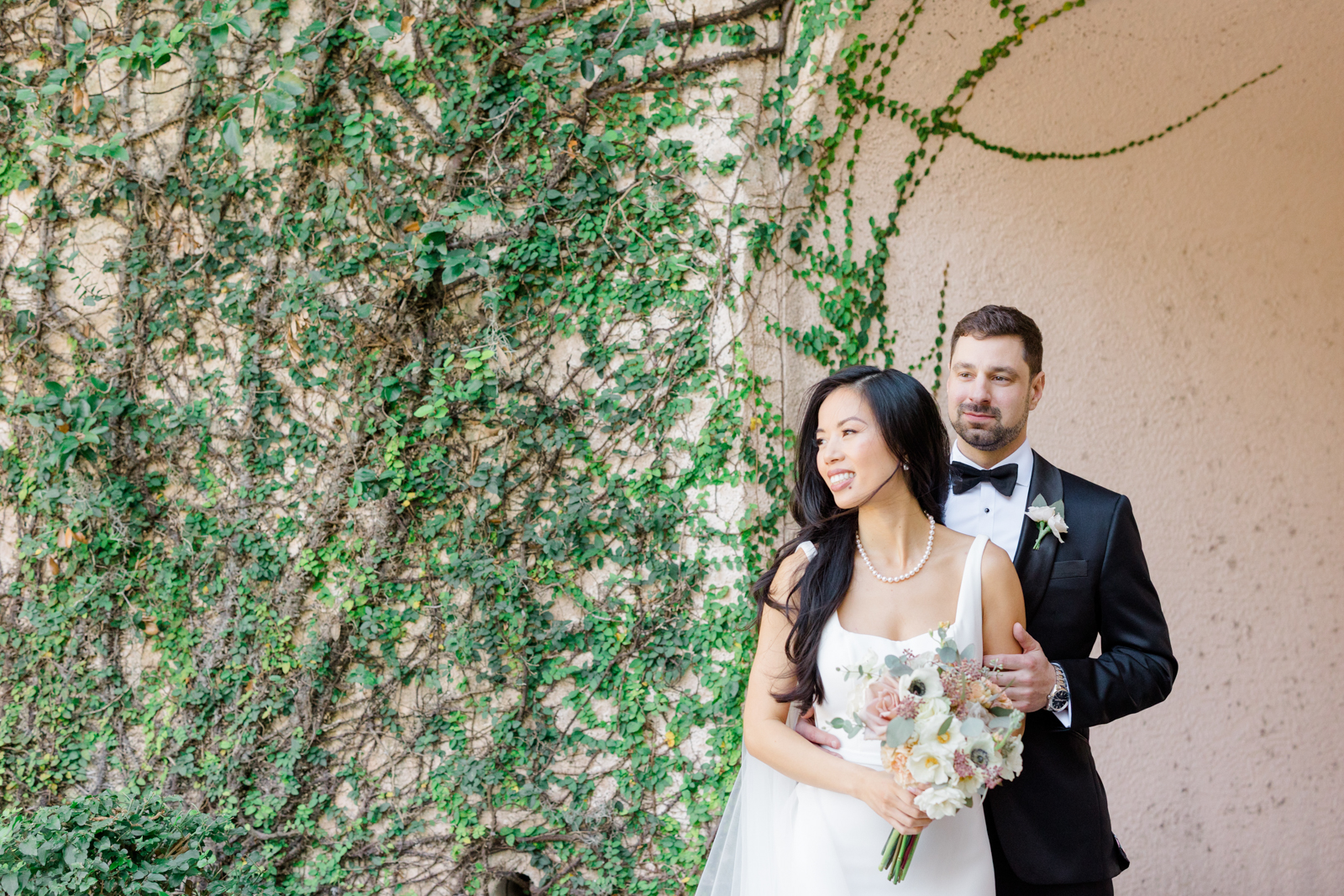 Bride and groom pose near ivy wall at Lakewood Ranch Golf & Country Club
