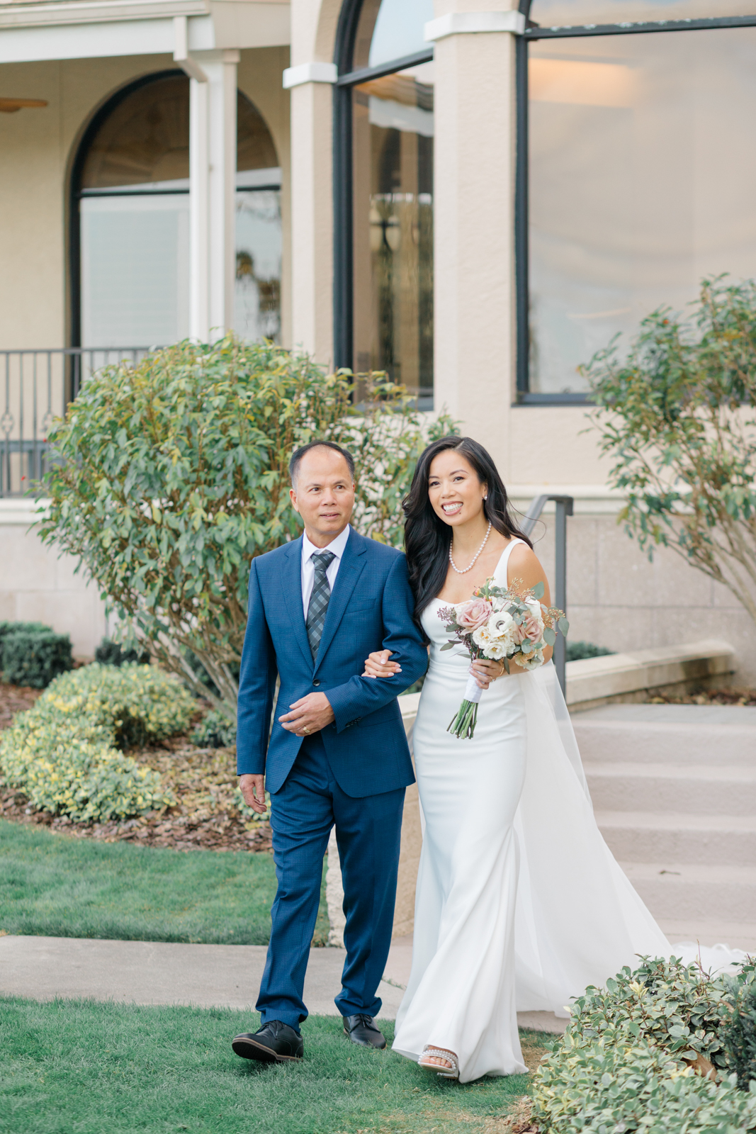 Bride and her father walk down the ceremony aisle smiling