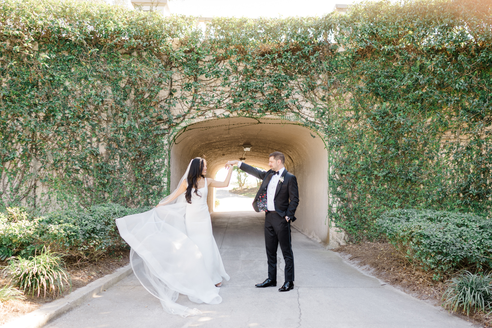Groom twirls bride near ivy wall at Lakewood Ranch Golf & Country Club